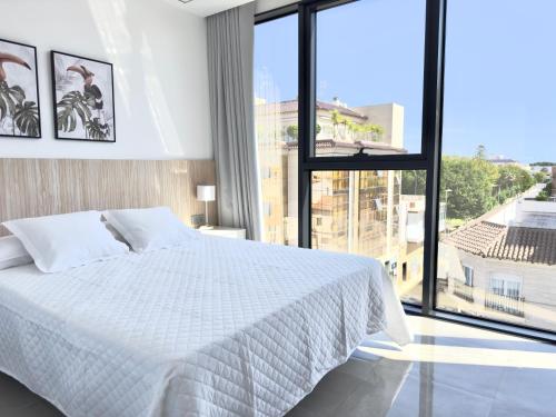 dormitorio cama blanca mesillas negras apartamento vacacional pilar de la horadada