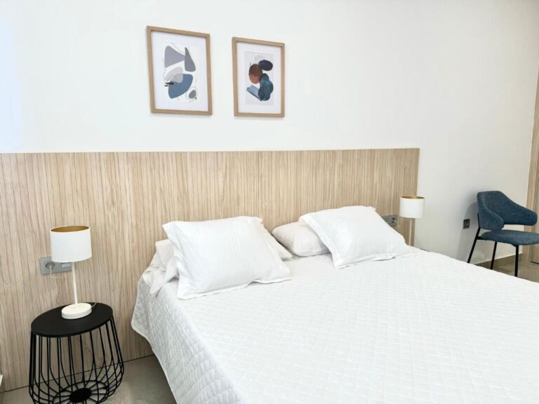 dormitorio cama blanca mesillas negras apartamento vacacional pilar de la horadada